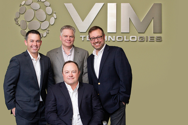 Four men posing for a business photo.