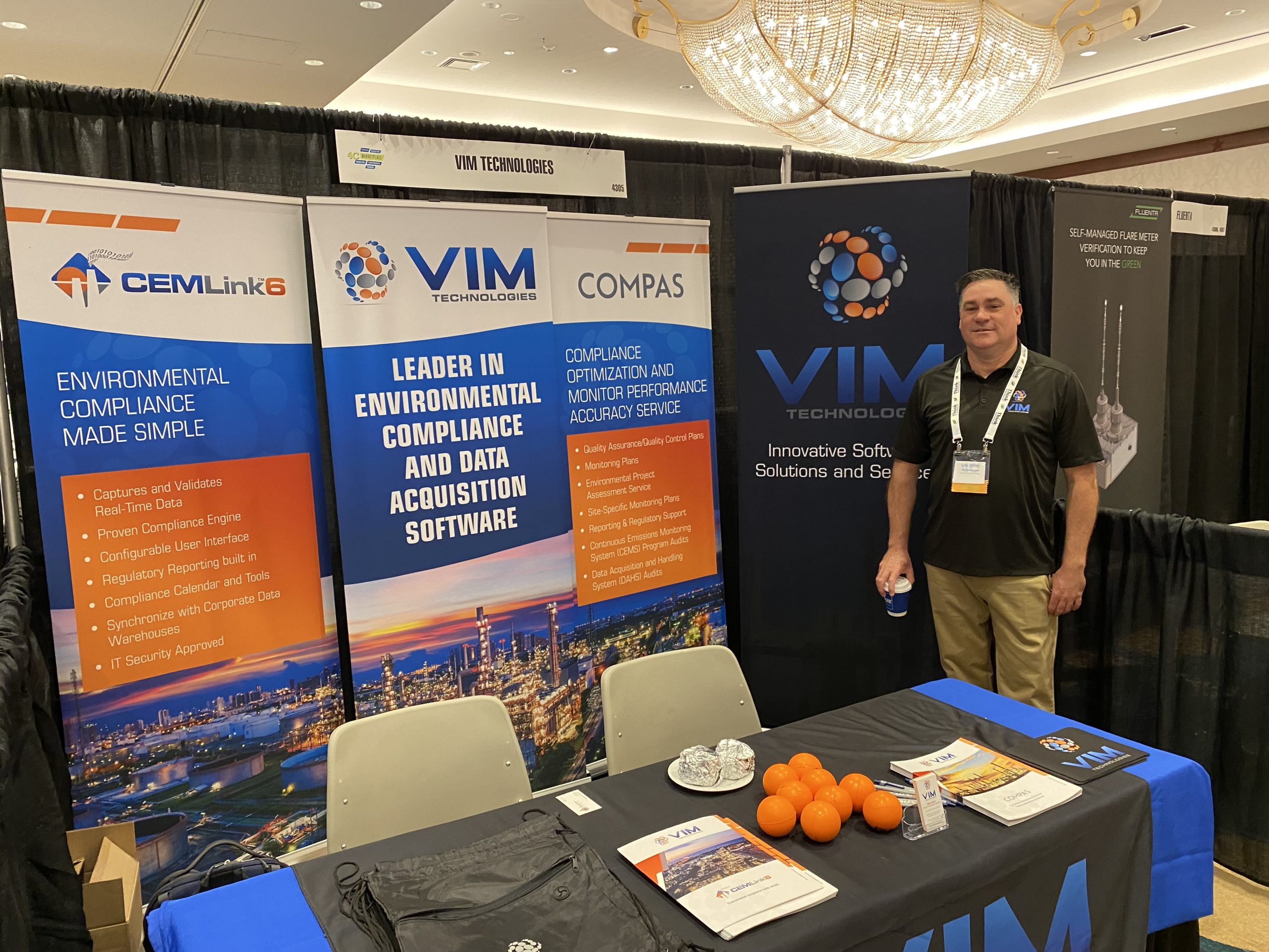 VIM Technologies conference exhibit with blue, white, and orange displays.